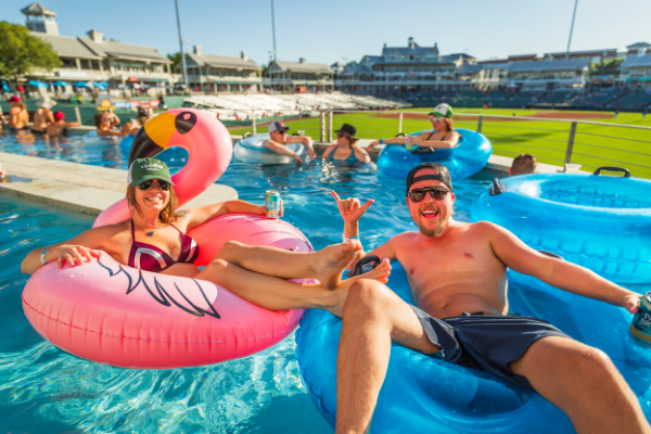 2022AugustEvents, two people in inflatable tubes on the lazy river with the baseball stadium in the background